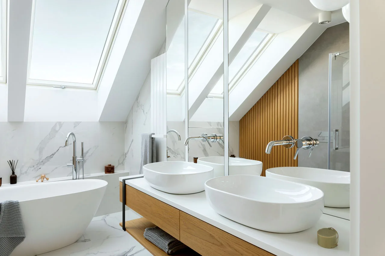 Attic bathroom with skylights, double vessel sinks and freestanding tub