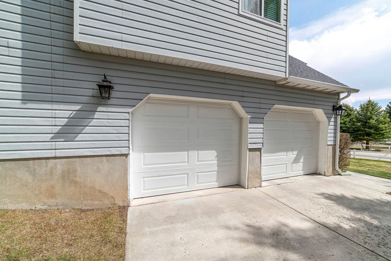 Two-car side-entry garage with white carriage doors